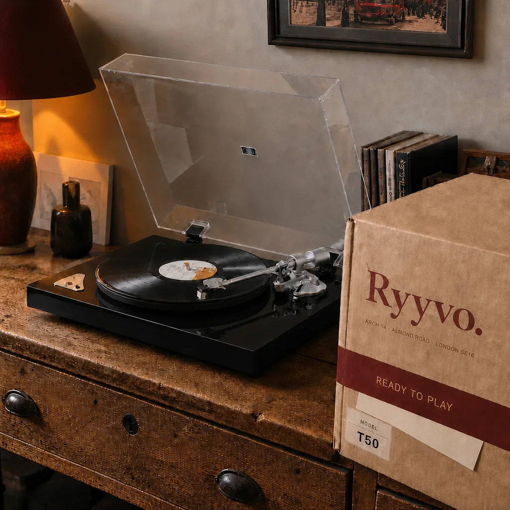 Ryyvo T50 record player in gloss black on a chest of drawers, dust cover raised, beside the opened Ryyvo carton